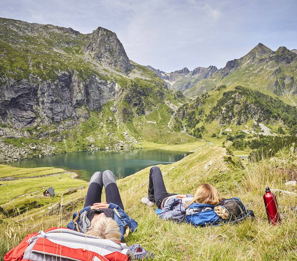 2 personnes font la sieste près du lac d'Espingo en montagne